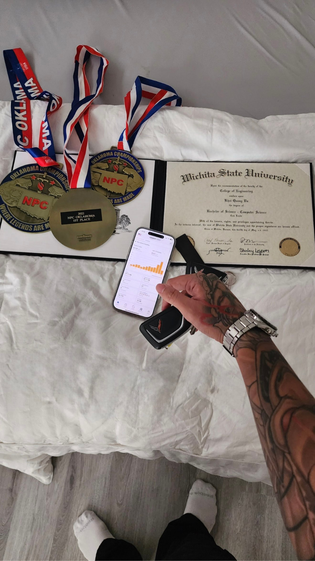 Diploma, championship medals, an Amazon sales dashboard and car keys
