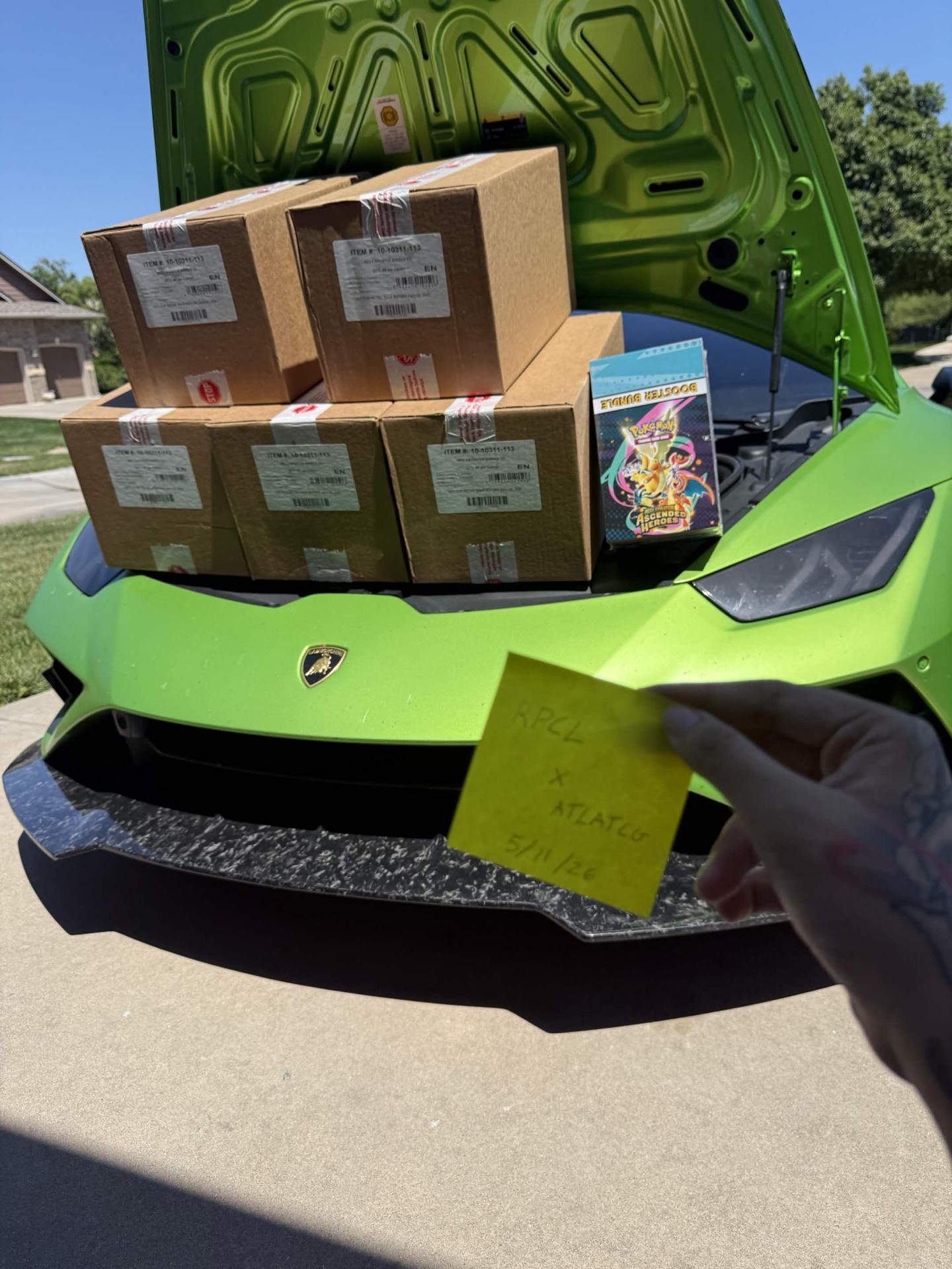 Pokemon TCG boxes loaded in a Lamborghini Huracan after a distribution pickup